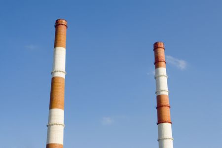 Two Red and white pipes on blue skyの写真素材