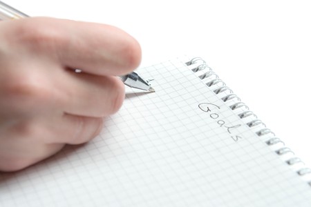 Writing goals in notebook on white groundの写真素材