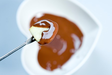 Piece of apple in chocolate fondueの写真素材