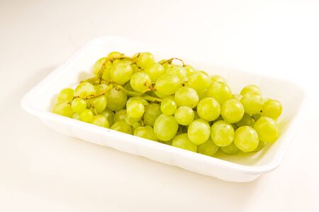 Grapes in tray on white groundの写真素材