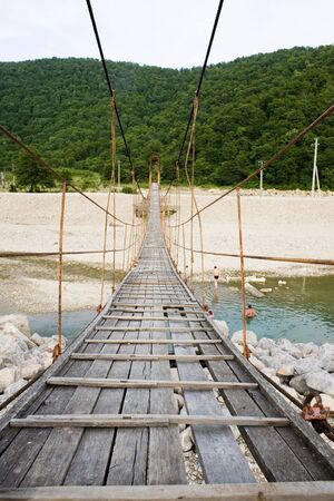 Old wooden bridge across the riverの写真素材