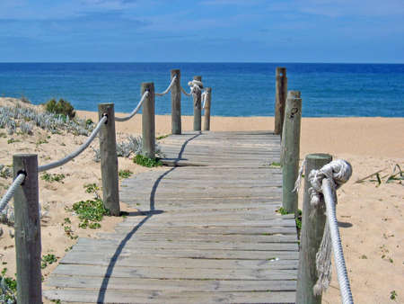 Wooden boardwalk ending at beachの写真素材