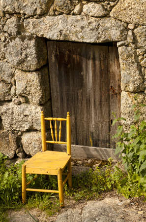 Door of an ancient house with a chair in the entranceの写真素材