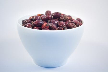 Bowl of dry rosehips in white bowl on white backgroundの写真素材