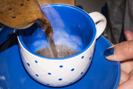 Pouring hot turkish coffee in coffee cupの写真素材