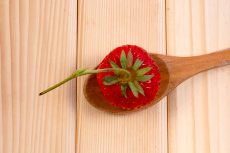 Strawberry  in the wooden spoon. Shot from the upper angle