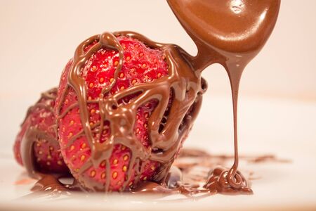 Plate with poured chocolate over strawberryの写真素材