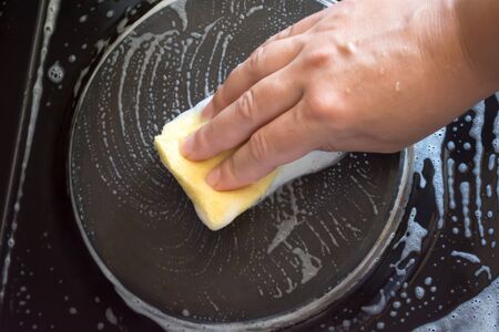 Close up of woman cleaning cooker at home kitchen