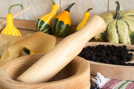 wooden mortar on wooden kitchen table with cracked pumpkin seedsの写真素材