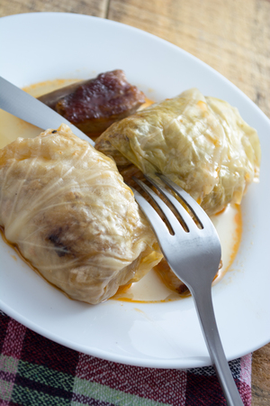 Serbian sarma (stuffed cabbage rolls) served on the white plate on wooden tableの写真素材