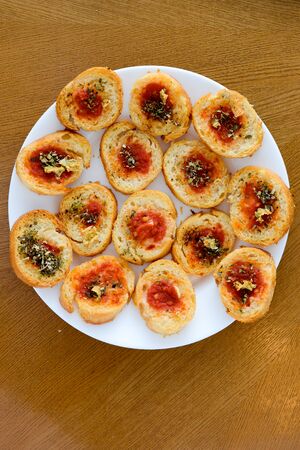 Light and delicious bruschetta appetizers with tomato amd oregano served on white plate
