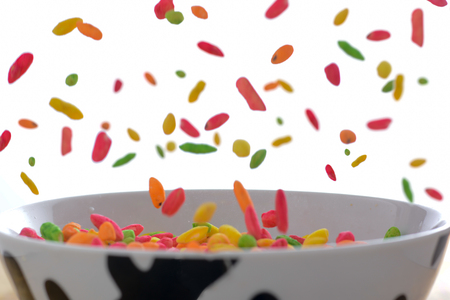 Colorful rice falling in the bowl on the white backgroundの写真素材