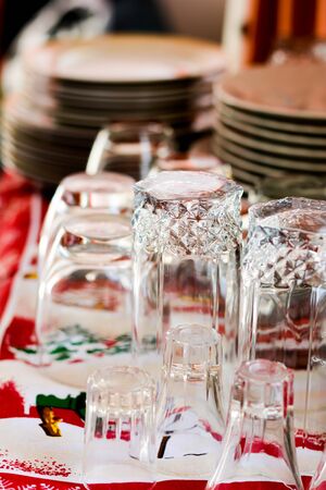 Washed glasses turned upside down and other various dishes on home tableの写真素材