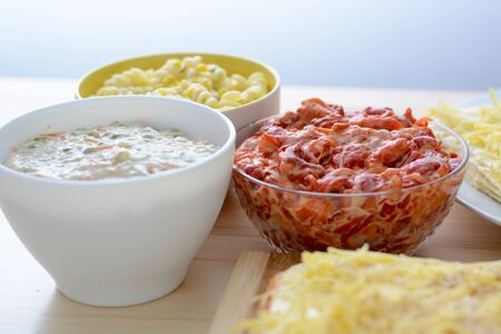 Colorful salads in ceramic bowls and salt cake with cheese and red paprika