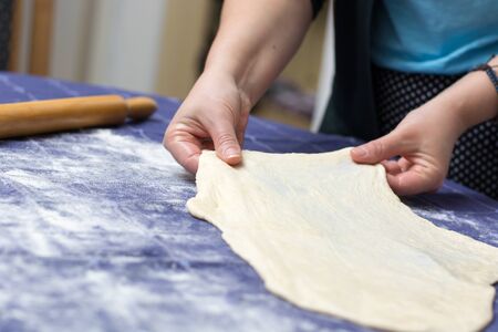 Creating homemade Phyllo or strudel dough on a home table cloth for cheese pie or other kind of...