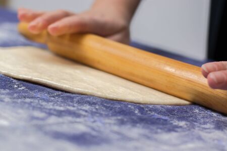 Creating homemade Phyllo or strudel dough on a home table cloth for cheese pie or other kind of traditional pastry.の写真素材