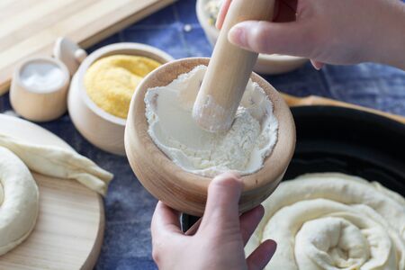 Female hand holding mortar and pestle with wheat flour  All around visible  wheat flour, corn flour,...