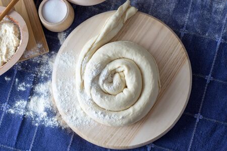 Cheese pie  on the wooden plate ready for baking Various ingredients in woodwork dishes. Cereals, wheat, salt, and other ingredients visibleの写真素材
