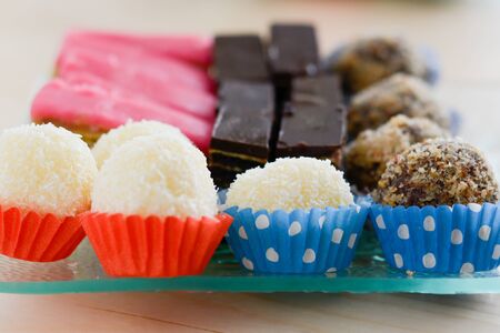 Colorful and delicious home made small cakes arranged on glass plate for celebration of the Saint dayの写真素材