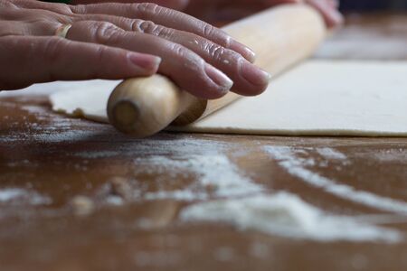 Woman making dough with meat at home on the kitchen tableの写真素材