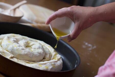 Woman making dough with meat at home on the kitchen tableの写真素材