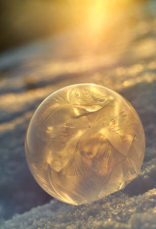 Frozen bubble on snowy mountains against the sun in the country sideの写真素材