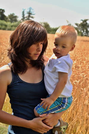 son in his mothers arms on the fieldの写真素材