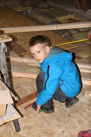 Handy little boy helps in building attic.の写真素材