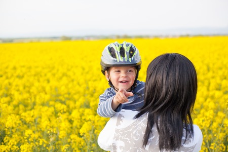 Portrait of a little boy in a helmet in an embrace with his mother.の写真素材