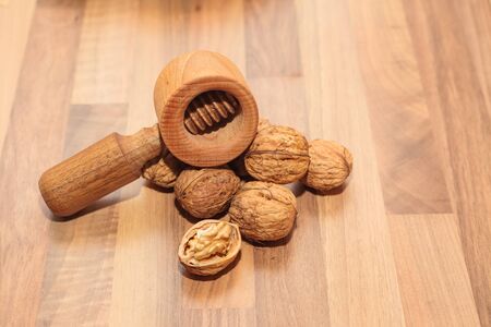 Walnuts with a nutcracker on a wooden board (Shallow DOF).