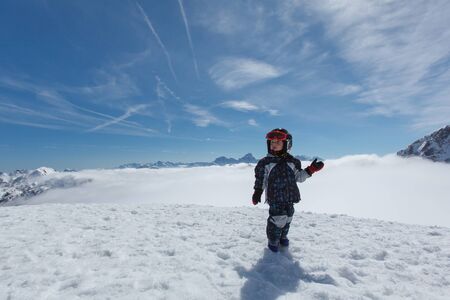 Cute little boy during skiing on alpine peakの写真素材
