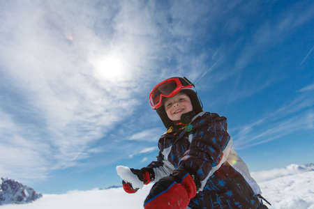 Cute little skier resting while skiing in the Austrian Alps.の写真素材