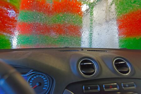 Automatic car wash. View from the car of a passing car washer (unfocused, blurry effect).の写真素材