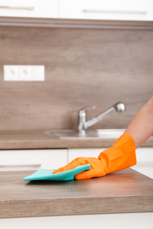 Hand in rubber glove cleans a new kitchen. Woman uklíví household chores in the kitchen.の写真素材