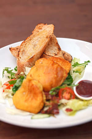 Potato pancakes with vegetable salad and homemade bread. Beautifully arranged food on a white plate. (Shallow DOF)の写真素材