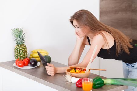 beautiful young girl preparing a healthy meal. Searches recipe using a tablet.の写真素材