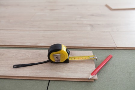 Laying of vinyl floor. Close-up of material and tools during work. (Shallow DOF)の写真素材