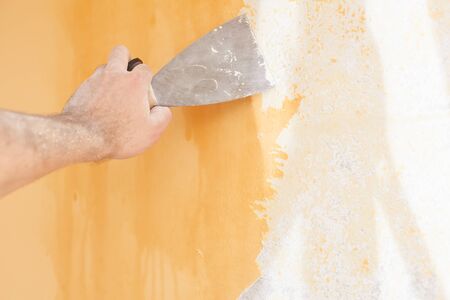 Scraping old plaster and applying new. Reconstruction of a new house.の写真素材