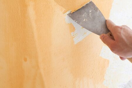 Scraping old plaster and applying new. Reconstruction of a new house.の写真素材