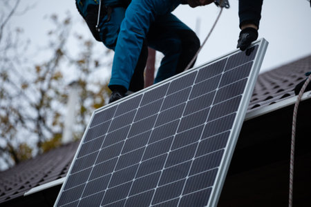 Installation of photovoltaic panels. Construction of the photovoltaic power plant of the family house.の写真素材