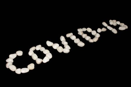 covid-19 text white royal sapphire rock pebbles letter photographed against a black background with blur- Imageの写真素材