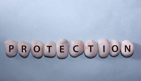 Concept Coronavirus. protection as a text with letters on white royal sapphire rock pebbles,...