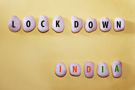 Concept Coronavirus. lockdown india as a text with letters on white royal sapphire rock pebbles,...