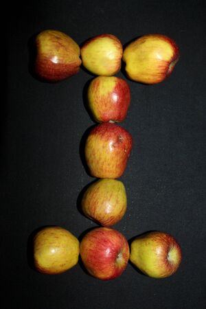 Colorful fresh apples letter alphabet photographed against a black background. - Imageの写真素材