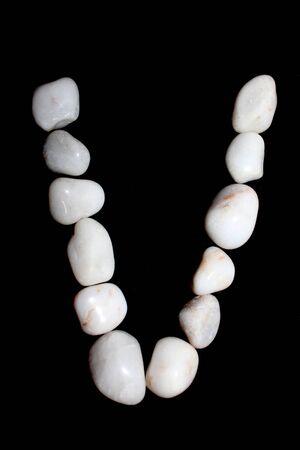 white royal sapphire rock pebbles letter, alphabet photographed against a black background. - Imageの写真素材