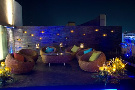 Romantic candle light private dinner, party setup in a restaurant with sofa table and furniture in nightの写真素材
