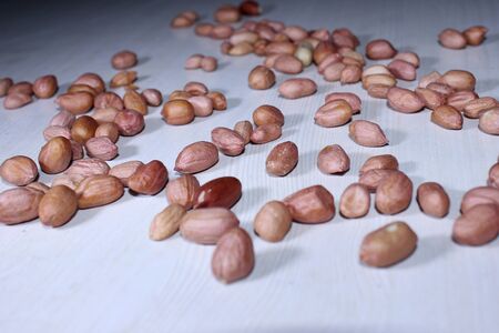 stock of traditional protein nutrition peanuts, fresh high fiber grain on white wooden background