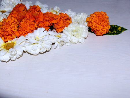 Beautiful triangle flower design with marigold, chrysanthemum flower and green leaves, traditional rangoli festival decoration on white backgroundの写真素材