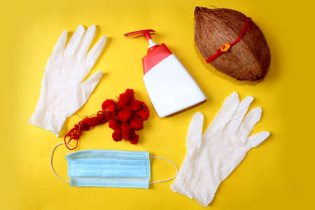 Raksha Bandhan Festival concept in Corona Virus or Covid-19, Rakhi or Wrist Band bracelet with sanitizer, gloves and protective mask for precaution over on yellow background.の写真素材