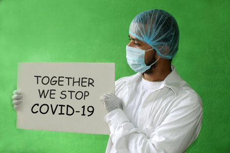 medical worker / doctor in a protective mask and gloves and holds a placard with the inscription "TOGETHER we STOP COVID-19". A call for solidarity, concept of covid-19.の写真素材